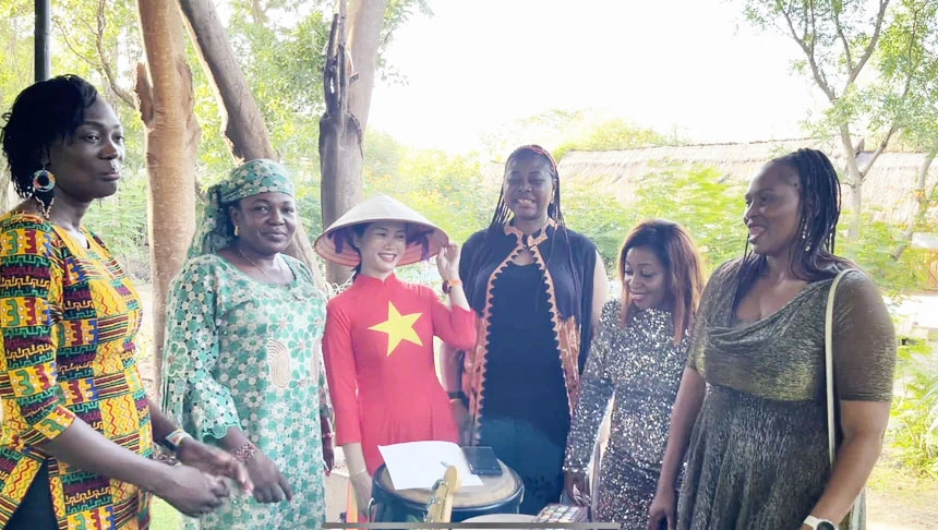Chị Lương Thị Trà Vinh mặc áo dài đỏ giao lưu thân thiệt với các bạn bè quốc tế tại Nam Sudan